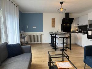 a living room with a couch and a table and a kitchen at La Promenade, T4 in secure residence in Saint-Brieuc