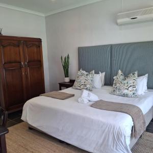 a bedroom with two beds with white sheets and pillows at Eshowe Hills Golf Estate in Eshowe