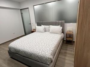 Un dormitorio con una cama grande con almohadas blancas. en Academys Modern Apartments by Athens Urban Retreat, en Atenas
