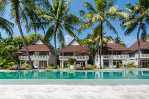 een resort met een zwembad voor palmbomen bij Sun Siyam Olhuveli in South Male Atoll