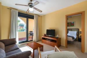ein Wohnzimmer mit einer Couch, einem Fernseher und einem Bett in der Unterkunft Playa Marina by Ĥ - Playa Punta del Moral PPHM319P74 in Punta del moral