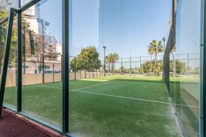 Durch ein Fenster ist ein Tennisplatz zu sehen in der Unterkunft Playa Marina by Ĥ - Playa Punta del Moral PPHM319P74 in Punta del moral