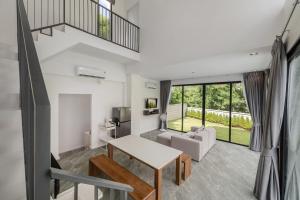 una sala de estar con una mesa y un sofá en Gina Poolvilla 6BR Pattaya, en Bang Sare