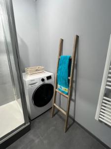 eine Waschküche mit einer Waschmaschine und einem blauen Handtuch in der Unterkunft Les Glycines in Le Touquet-Paris-Plage + 2 Fotos