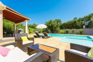 a patio with wicker furniture and a swimming pool at Villa Popi in Roda