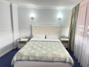 a bedroom with a large bed with two night stands at Байтерек рядом Министерство in Astana