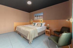 a bedroom with a large bed and a chair at PREMIUM B&B Nova Gorica, Self Check-In with code access in Nova Gorica
