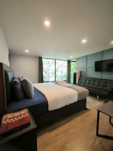 a bedroom with a large bed and a flat screen tv at Grapes Garden Resort Hunza in Hunza Valley