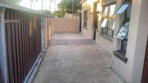 Un callejón de ladrillos con un edificio y una valla. en SABATH LODGE, en Ciudad del Cabo