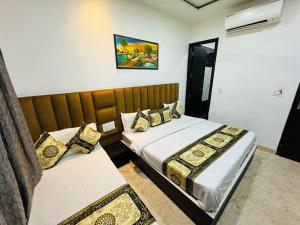 a bedroom with two beds and a mirror at Yuvraj Residency - 1 minute walking from Golden Temple in Amritsar +5 photos