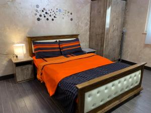 1 dormitorio con 1 cama con manta naranja y almohadas en Apartment Near Republic Square Yerevan, en Ereván