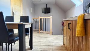 a room with a table and chairs and a television at Apartament u Bartosów in Czarny Dunajec
