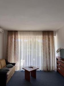 a living room with a couch and a table in front of a window at ''ROOM 6'' - breakfast included in Kampor +4 photos