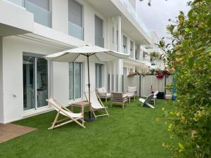 un patio con sillas de césped y una sombrilla en Costa Ballena Terrace Beach House, en Costa Ballena