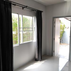 an empty room with a window and a door at The first house 11126 in Ban Phlu Yai