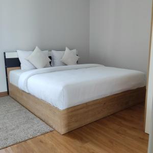 a bed with white sheets and pillows on it at The first house 11126 in Ban Phlu Yai