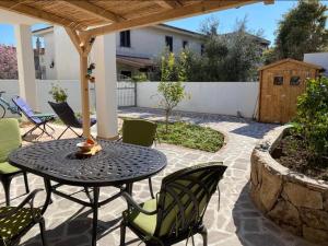 een terras met een tafel, stoelen en een hek bij Casa Marisol in Orosei