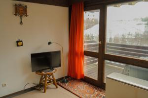 Μια τηλεόραση ή/και κέντρο ψυχαγωγίας στο Ferienwohnung Schimmer mit Bergblick im ruhigen, naturverbundenen Ferienpark Vorauf, Siegsdorf