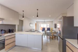 a kitchen with white cabinets and a dining room at Group House 2 - 1 On York in George