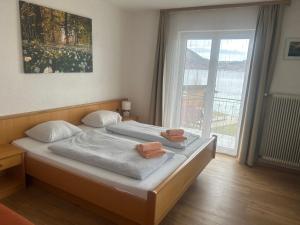 魏勒格Gasthof mit Seeterasse & Appartements Zur Landeroith的一间卧室，床上有两条毛巾