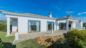 a white house with a large deck in front of it at Villa Areias II - Beautiful landscape garden in Estói