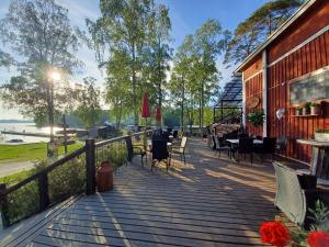 a wooden deck with chairs and tables on a building at Pyhäranta Camping & Kievari in Pyhäranta +8 photos