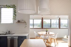 ヤンバにあるBay Properties Casetta Bluのテーブルと椅子のあるキッチンとダイニングルーム