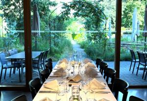 a dining room with tables and chairs and a large window at ODELYA - Stadthotel im Park in Basel
