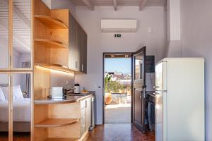 a kitchen with a refrigerator and a bedroom at Chryssi Seafront Living, 03 Suite, right on the beach in Rethymno! in Rethymno Town