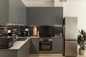 une cuisine avec des appareils en acier inoxydable et du carrelage noir dans l'établissement Saint Matthew Central Apartment by Senaon, à Héraklion