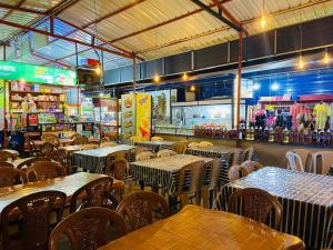 a restaurant with tables and chairs and a store at Shan Hotel in Nallathanniya