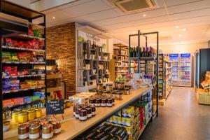 a grocery store aisle with a counter with food at Dormio Resort Maastricht in Maastricht
