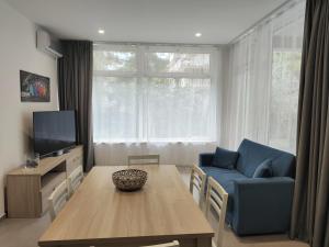 a living room with a blue couch and a table at Homiday - Luminoso in Pineto