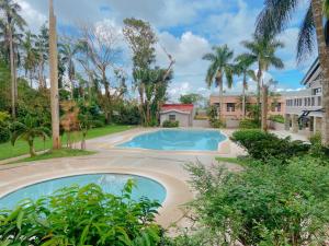 a swimming pool in a yard with palm trees at A nature’s den in Tagaytay in Tagaytay