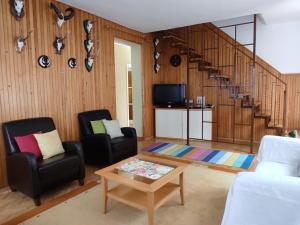a living room with two chairs and a spiral staircase at Magdaléna Holiday Home in Zalakaros