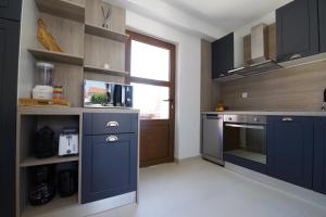 a large kitchen with blue cabinets and a window at Villa Dora with heated pool & fitness in Gradina +40 photos