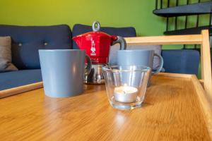a table with three coffee cups and a tea kettle at Maisonette-Ferienwohnung Karla in Ostseebad Karlshagen