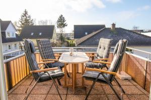 a table and four chairs on a balcony at Maisonette-Ferienwohnung Karla in Ostseebad Karlshagen