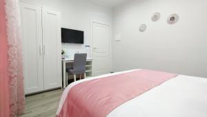 a white bedroom with a bed and a desk at Black Horse in San Giorgio a Cremano