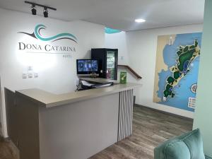 a reception desk with a sign on the wall at Dona Catarina Hotel in Florianópolis +18 photos