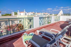a patio with two chairs and a table on a balcony at Casa Estrelinha Vilamoura in Quarteira