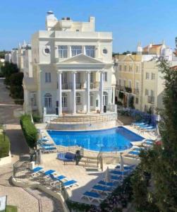 a large white mansion with a swimming pool at Casa Estrelinha Vilamoura in Quarteira