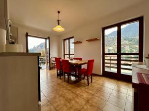 a kitchen and dining room with a table and red chairs at Kibilù - Il Nido di Laveno in Varese +27 photos