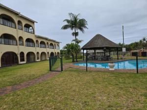 ein Gebäude mit einem Pool und einem Pavillon in der Unterkunft 16 Cabanas Del Mar Winklespruit KZN South Coast in Kingsborough