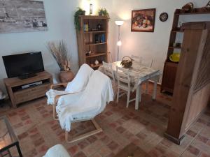 un soggiorno con tavolo, sedia e TV di Cortijo El Almendro, Urb. Fuente del Gallo, Conil a Conil de la Frontera