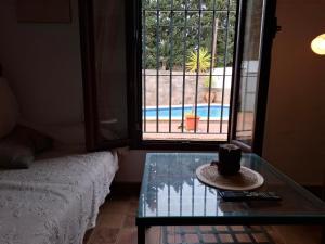 una camera con un tavolo in vetro e una finestra di Cortijo El Almendro, Urb. Fuente del Gallo, Conil a Conil de la Frontera Altre 7 foto