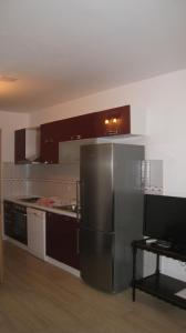 una cucina con frigorifero in acciaio inossidabile e tavolo di Apartment "Kod None" a Vis