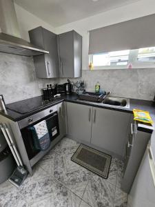 a small kitchen with a sink and a stove at 41 Cherry Park in Chapel Saint Leonards +5 photos