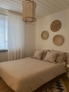 a bedroom with a bed and a chandelier at F I E R Huisje in Eersel