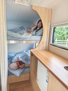 two people laying on beds in a tiny house at The Starry Campervans Cameron Highlands in Cameron Highlands